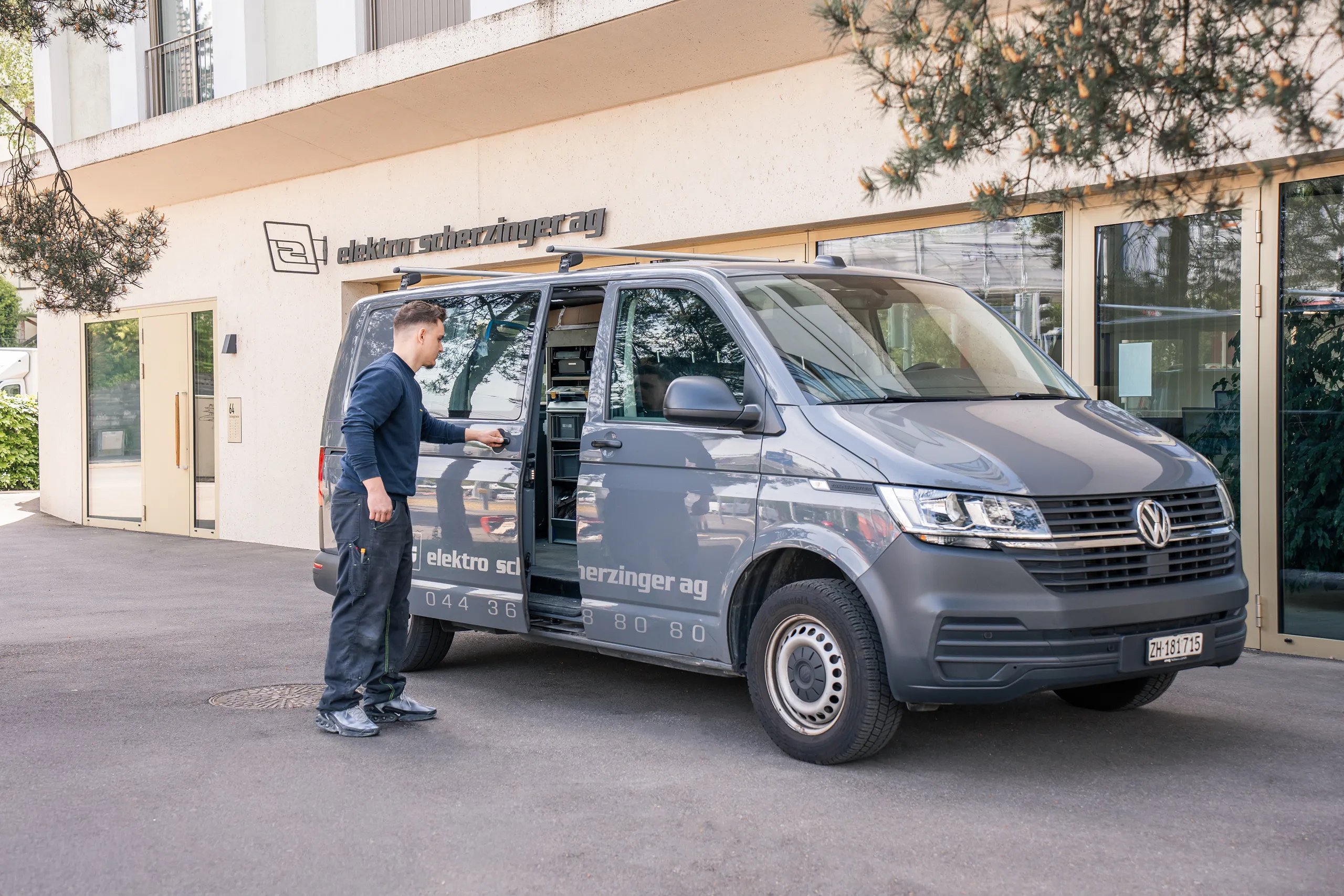 Monteur der elektro scherzinger ag steigt vor dem Geschäft in das Montagefahrzeug